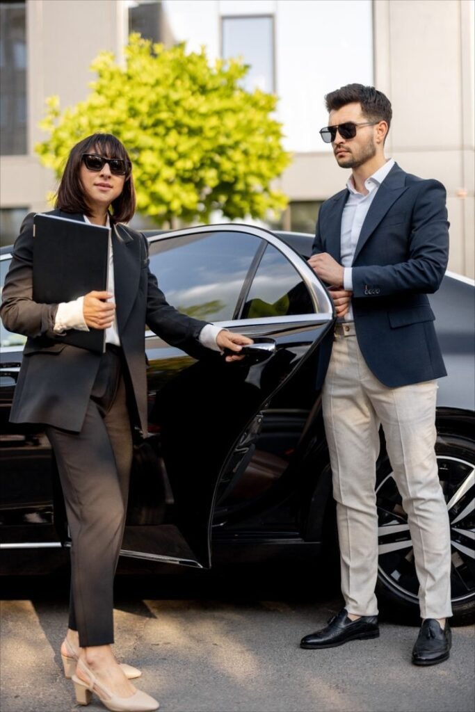 Professional chauffeur opening luxury car door for businesswoman – NYC limo services for executive transportation