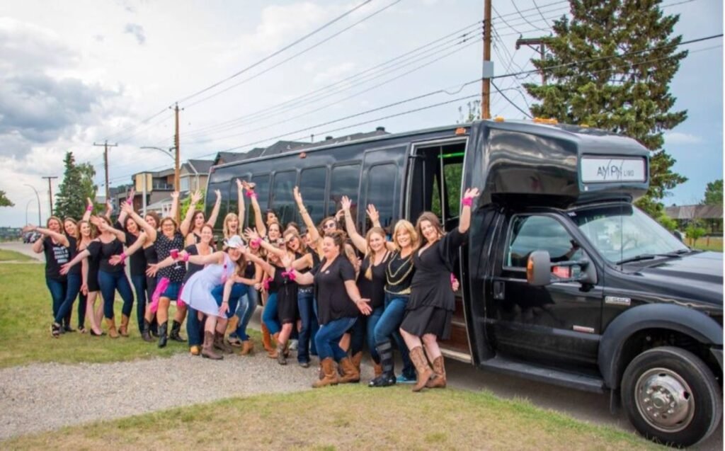 How to Plan and Coordinate Transportation for Large Groups or Multiple Destinations in NYC? 38 Group of women celebrating outside a black party bus, dressed in casual attire with pink accessories, enjoying the event.