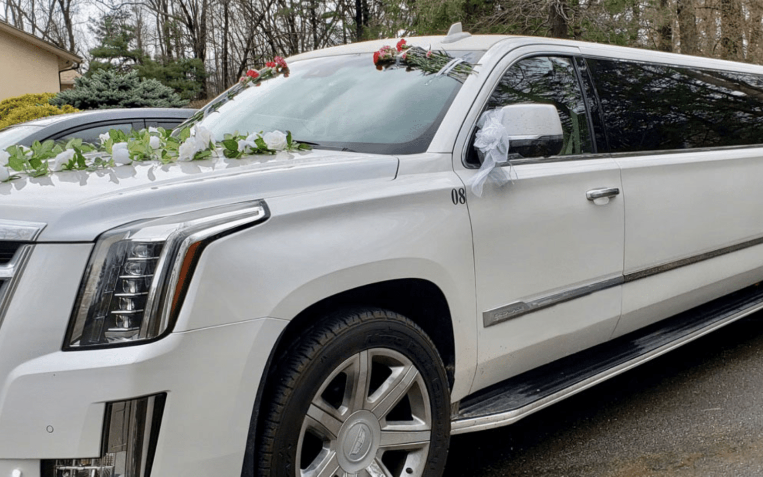 Elegant white wedding limo adorned with flowers and ribbons, ready to make a grand entrance on your special day.