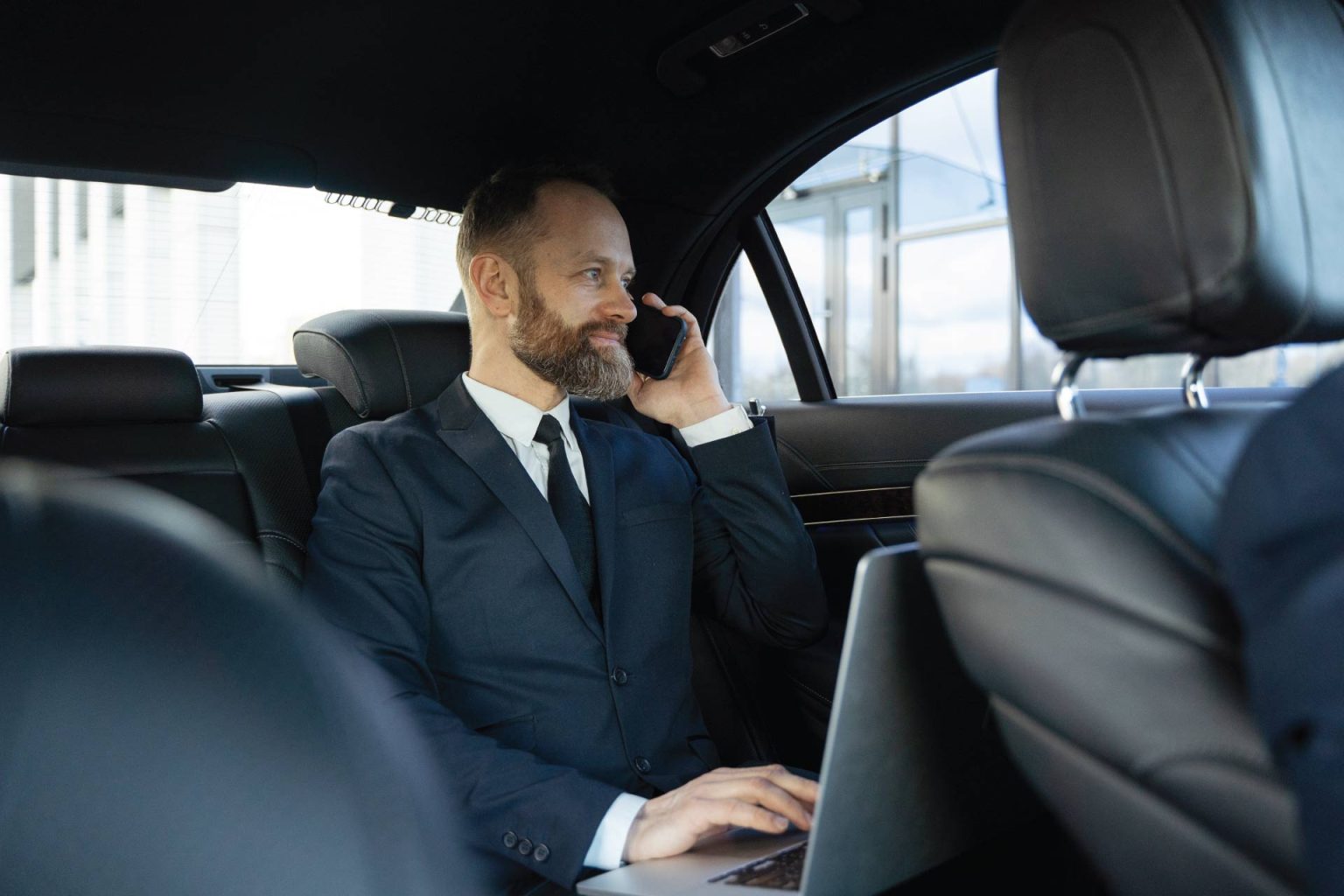 A sleek black stretch limousine parked by the waterfront with the New York City skyline in the background, symbolizing luxury transport.
