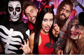 What is Halloween Day, and Why Do We Celebrate It? 31 Group of friends in Halloween costumes posing playfully, dressed as a skeleton, vampire, devil, and witch at a party.