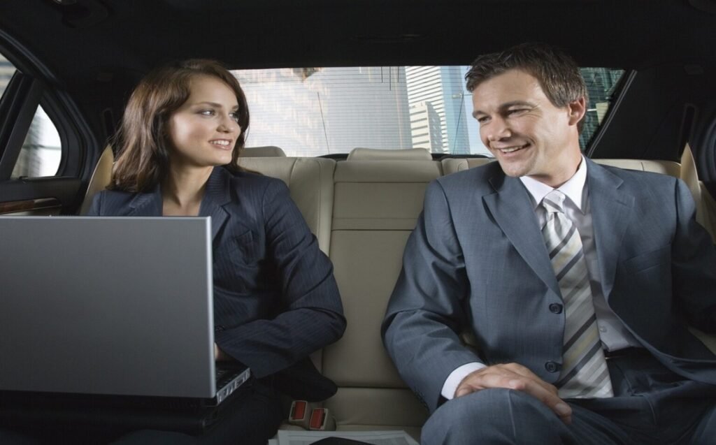 Choosing the right limo or car service for corporate events and meetings in NYC 4 Two business professionals talking in a luxury car, representing corporate limo service for business travel.