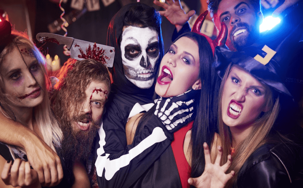 Get Spooked in Style With Epic Halloween Limo Journeys in NYC 29 Group of young adults in spooky Halloween costumes posing together at a themed party, with festive decorations and dramatic makeup.