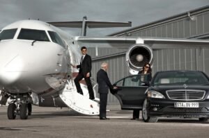 Luxury black Mercedes-Benz and private jet, chauffeur assisting executives—exclusive corporate airport transfer service.